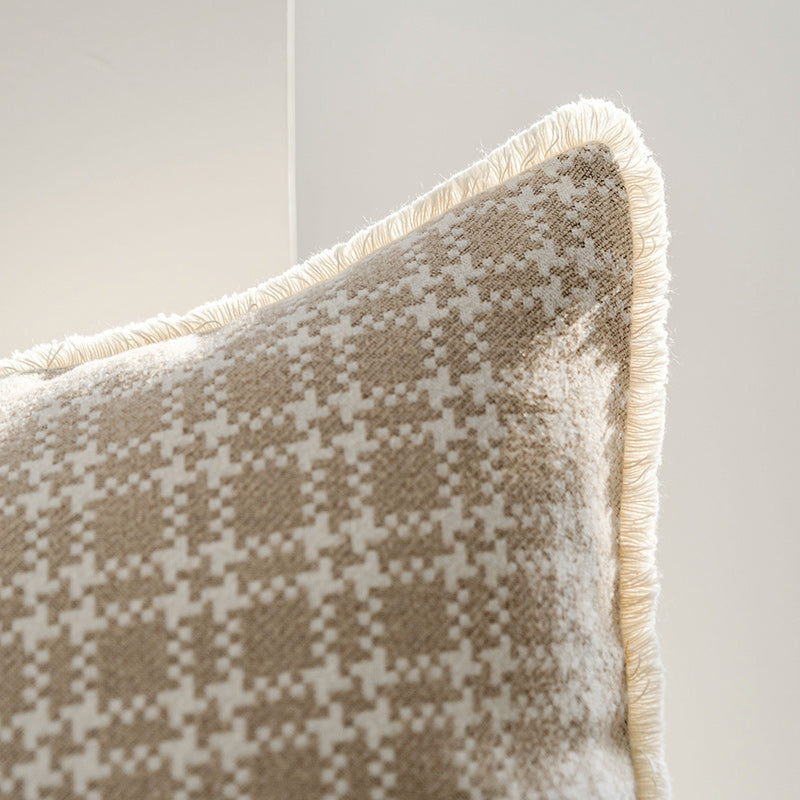 Patterned pillow with frayed edges on a neutral background