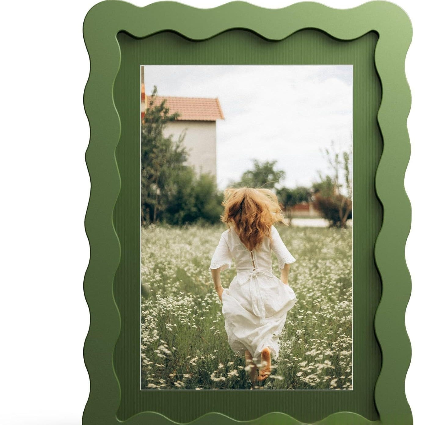 Green picture frame with a photo of a woman in a white dress running through a field.