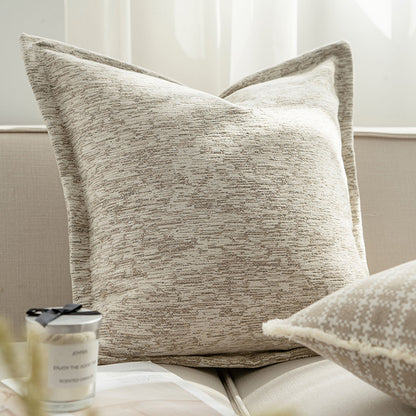 Textured throw pillow on a sofa with a candle in the foreground