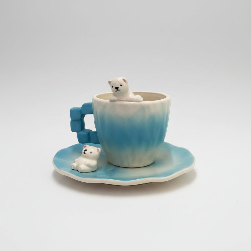 Blue and white ceramic teacup and saucer set with polar bear figurines, shown with dimension lines and measurements on a white background.
