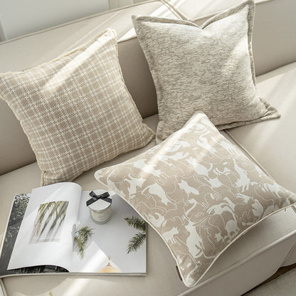 Decorative pillows on a sofa with a magazine and small bowl.