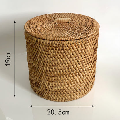 A round woven rattan storage basket with lid in a natural tan color, shown on a white background with text indicating dimensions: 19 cm height and 20.5 cm diameter, plus a note about manual measurement error.
